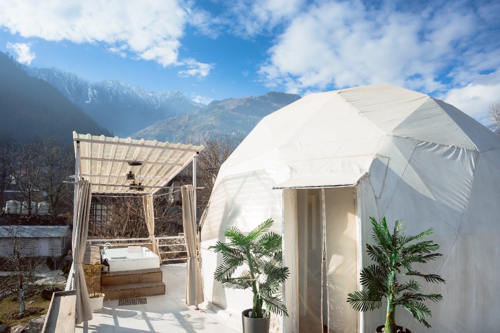 Geodesic dome with outdoor jacuzzi deck and mountain backdrop